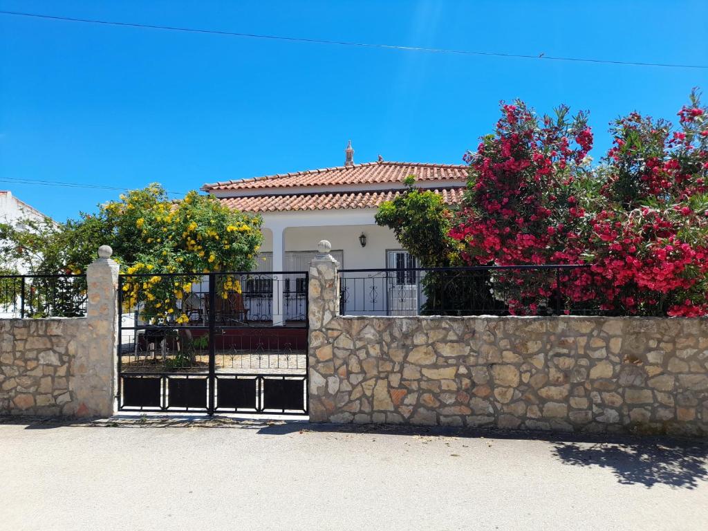 a fence in front of a house with flowers at Belamandil Garden ,family holidays ,caminho do torrejao olhao in Olhão