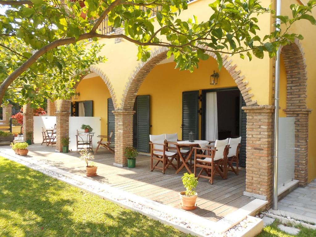 una terraza al aire libre con mesa y sillas en una casa en Villa Sofia en Parga