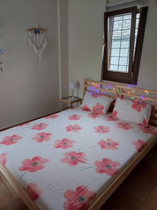 sypialnia z łóżkiem z różowymi kwiatami w obiekcie Marilia Home w mieście Afissos