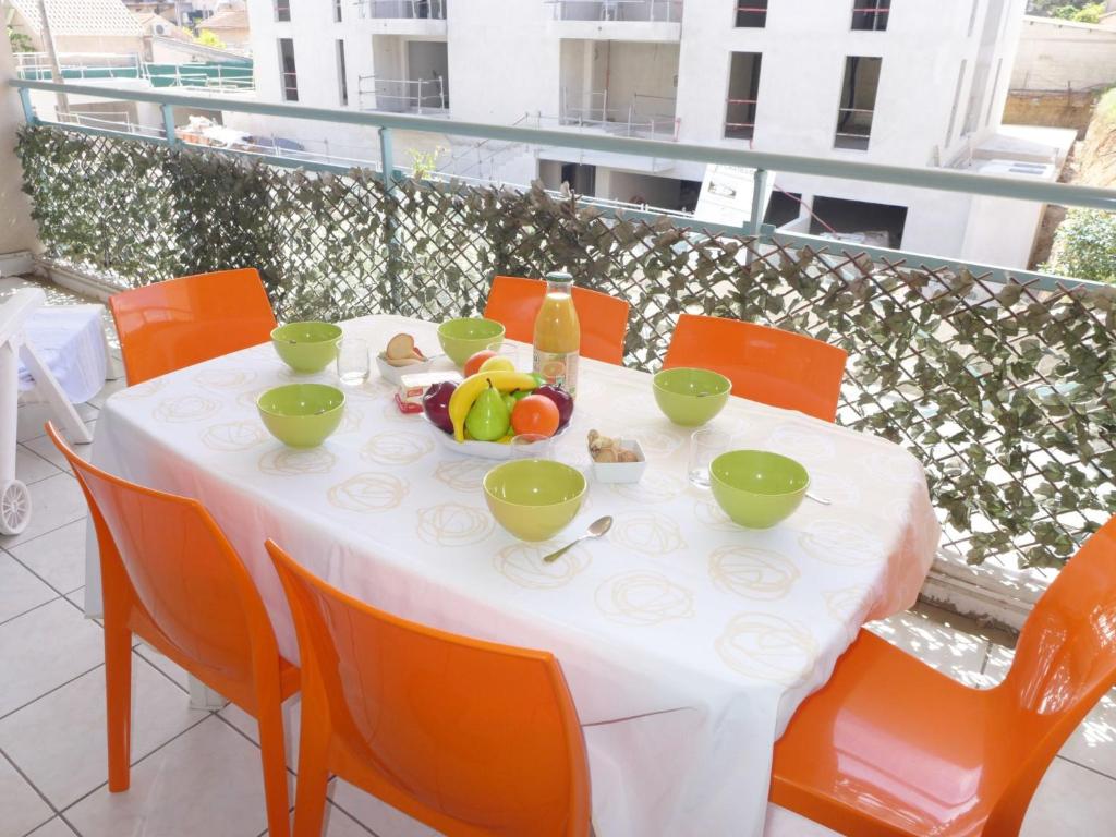 une table avec des bols de fruits sur un balcon dans l'établissement Apartment Le Clos Saint Saens-1 by Interhome, à Saint-Aygulf