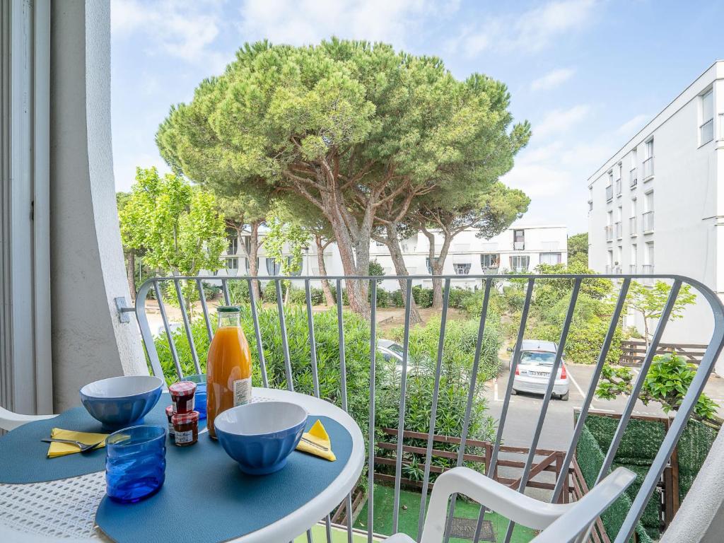 a table and chairs on a balcony with a tree at Apartment Marin&#39;Land by Interhome in La Grande Motte