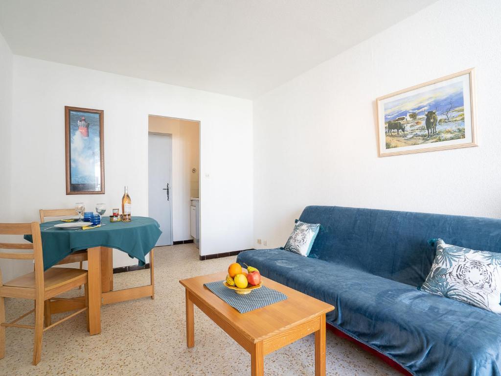 a living room with a blue couch and a table at Apartment Marin&#39;Land by Interhome in La Grande Motte
