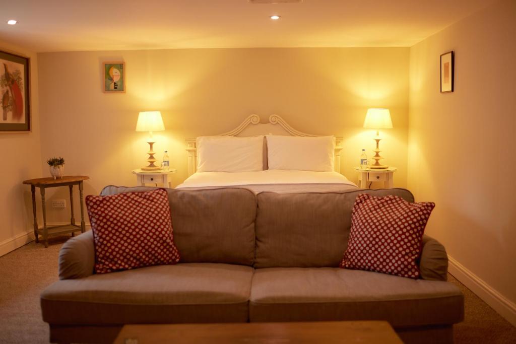 uma sala de estar com um sofá e uma cama em The Grosvenor Arms em Hindon