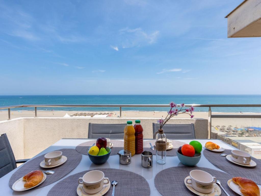 カネ・アン・ルシヨンにあるApartment MUMBA by Interhomeのビーチの景色を望むテーブル(食事付)