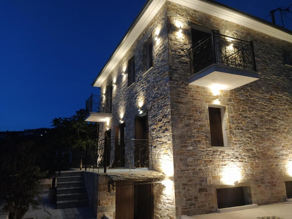 a stone building with lights on it at night at CAPTAINHOUSE in Afissos