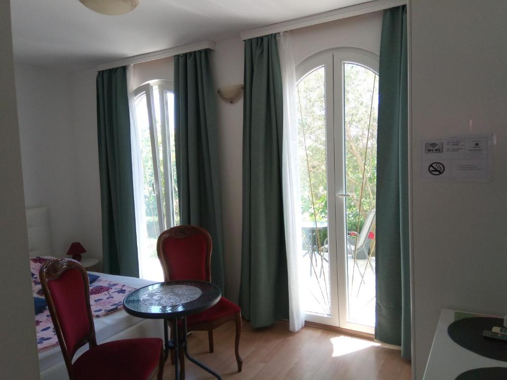 a room with a table and chairs and a sliding glass door at Ana Rooms in Krk