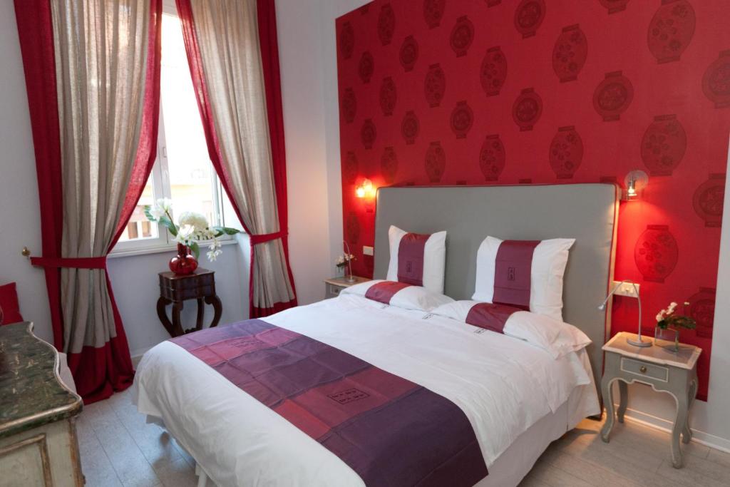 um quarto com uma cama grande e paredes vermelhas em 66 Imperial Inn Deluxe B&B em Roma