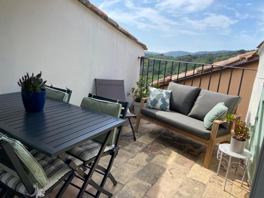 a patio with a table and chairs on a balcony at Maison coeur de village Ramatuelle in Ramatuelle