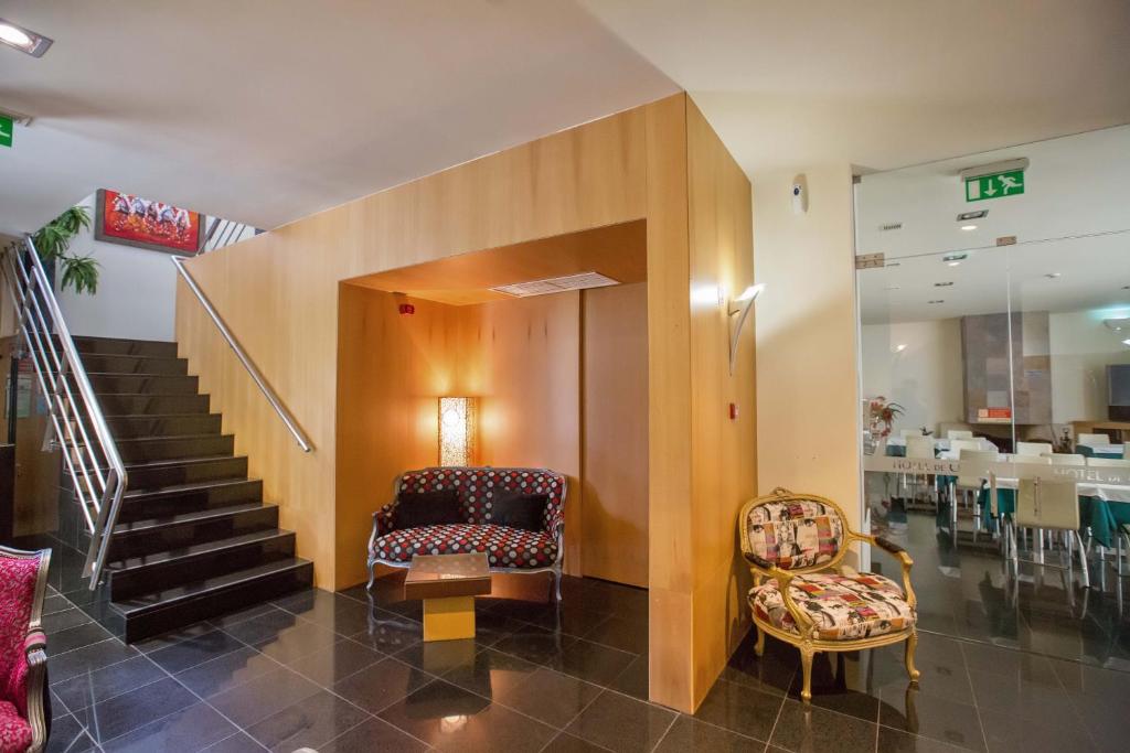 a lobby with a staircase and a chair and a table at Hotel De Cerva in Cerva