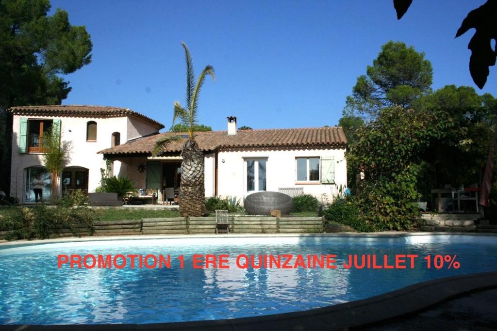 a house with a swimming pool in front of a house at Villa au calme sans vis à vis in Fayence