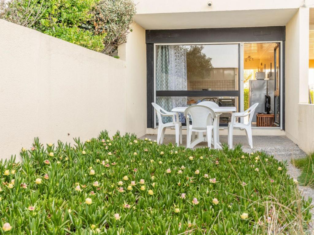 een patio met witte stoelen en een tafel bij Apartment Les Océanides-4 by Interhome in Lacanau-Océan