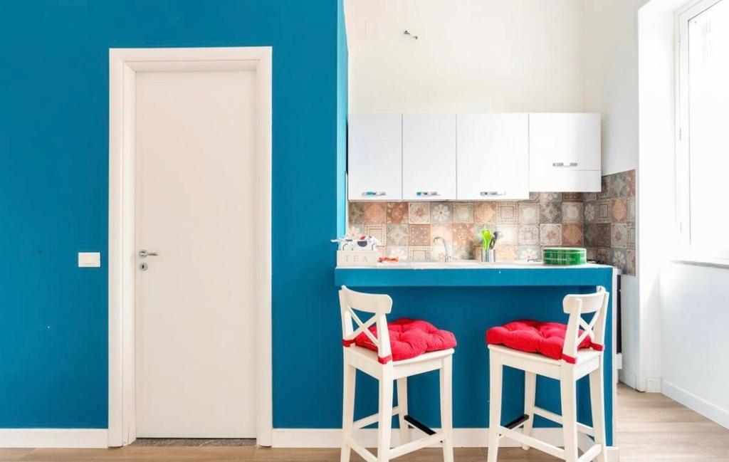 eine Küche mit einer blauen Theke und 2 Hockern in der Unterkunft Funky flat in Palermo