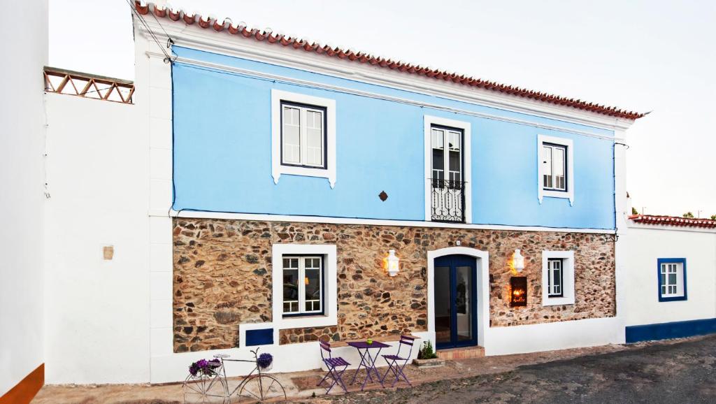 a blue house with chairs in front of it at Casa da Tia Amalia in Mértola