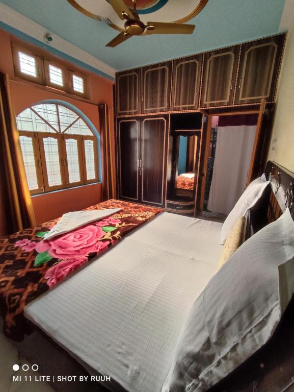 a bedroom with a large bed with a flower blanket at Ganga Lakshya Dham in Uttarkāshi