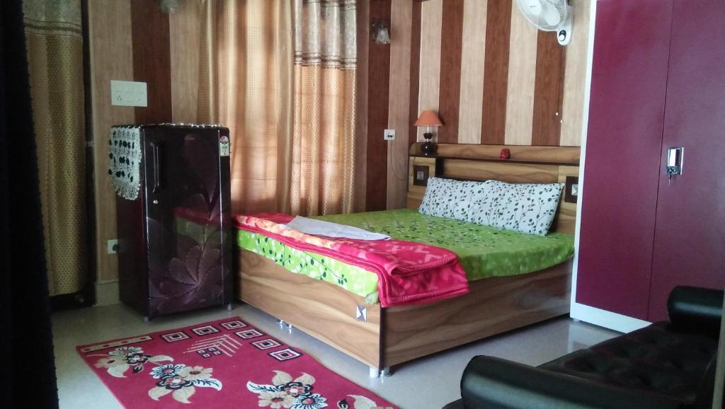 een kleine slaapkamer met een bed met een groene matras bij Ganga Lakshya Dham in Uttarkāshi