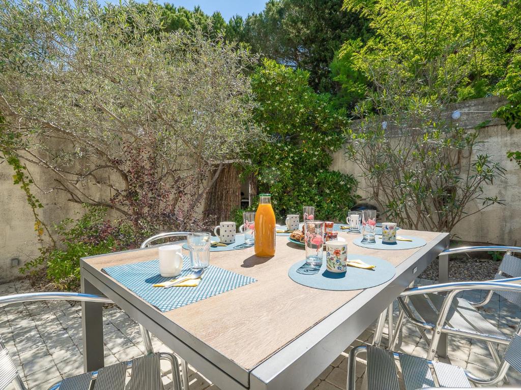 une table en bois avec des assiettes de nourriture dessus dans l'établissement Holiday Home Villas Plein Soleil 1 by Interhome, à La Grande Motte
