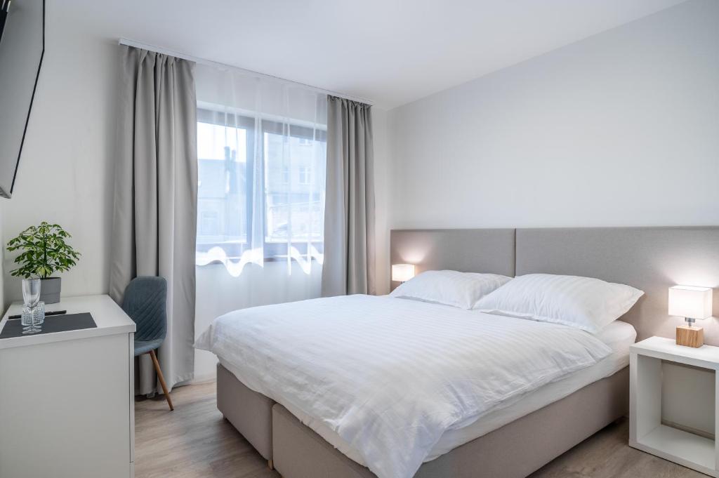 Un dormitorio blanco con una cama grande y una ventana en 4 pokoje, en Ostrava