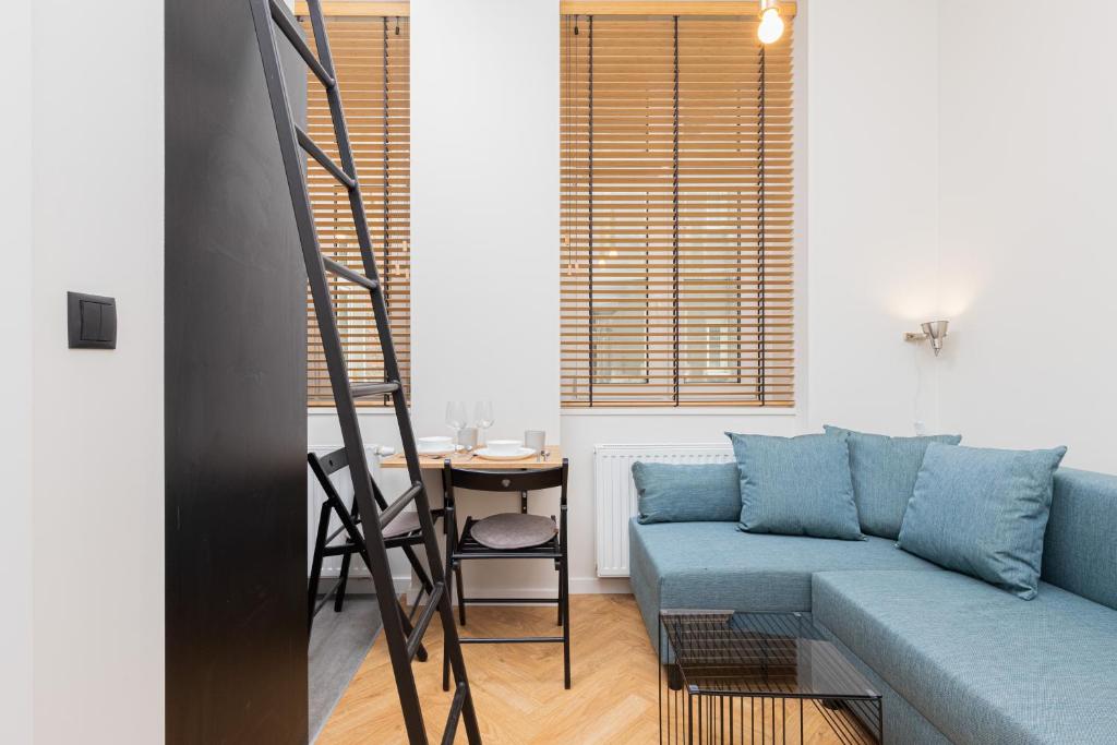 a living room with a blue couch and a table at Nad Motlawa Apartamenty Seredynskiego by Renters in Gdańsk