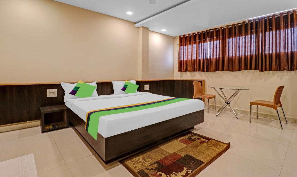 Treebo Trend Surya Yatri Niwas في بلغاوم: غرفة نوم بسرير وطاولة وكراسي