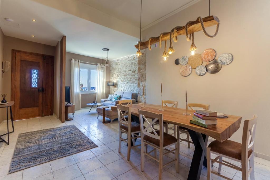 a dining room and living room with a wooden table and chairs at Evangelia Residenza, elegant stay in Herakleion! in Heraklio