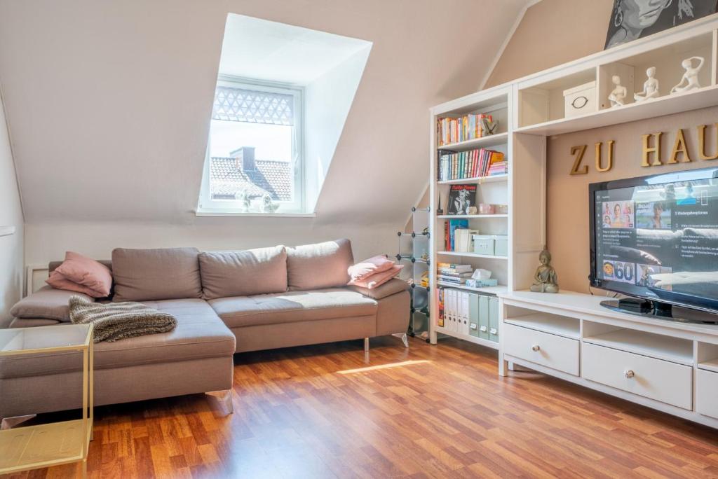ein Wohnzimmer mit einem Sofa und einem TV in der Unterkunft Private Apartment in Hannover