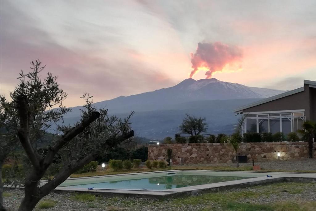 una erupción de un volcán detrás de una casa con piscina en Villa Mida, en Calatabiano