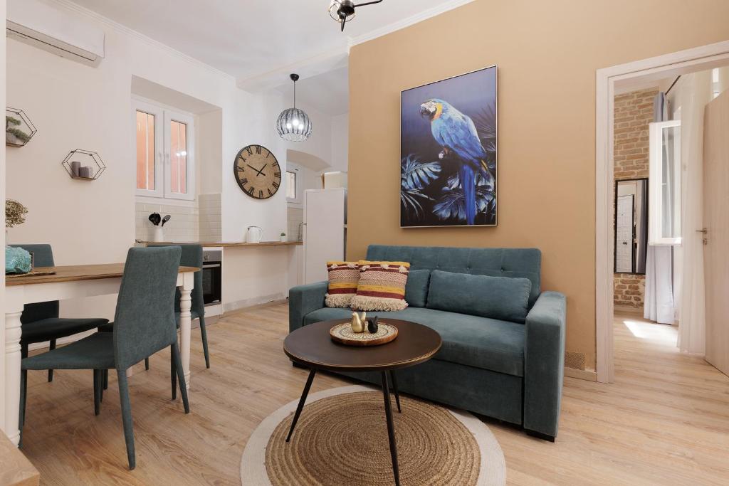 Spianada Collection of Studios & Apartments by Konnect في مدينة كورفو: غرفة معيشة مع أريكة زرقاء وطاولة