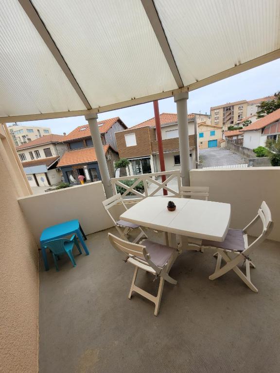 d'un balcon sur le toit avec une table et des chaises. dans l'établissement Douceur Océanne, à Mimizan
