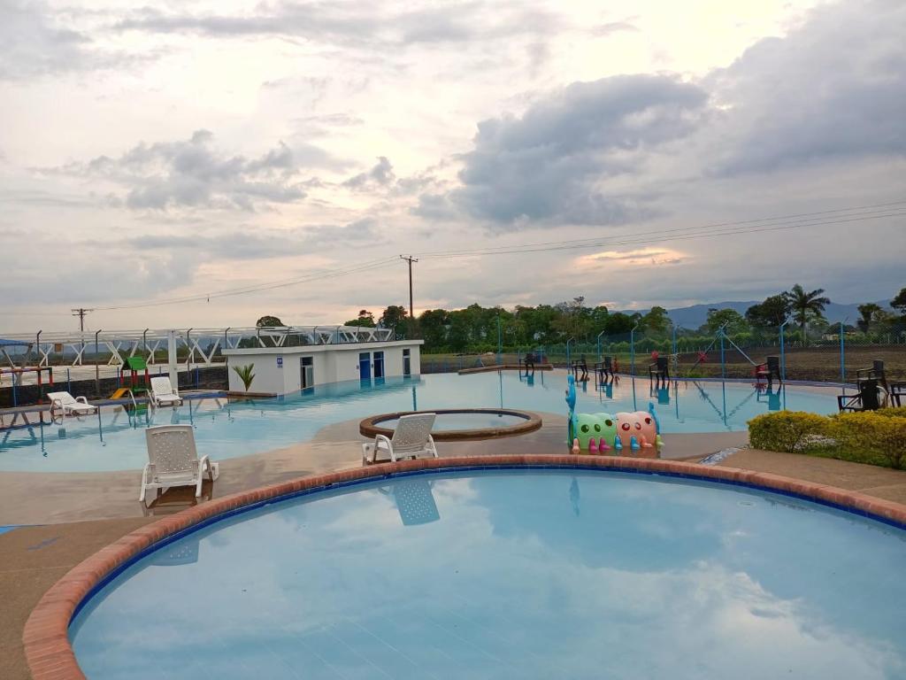 a swimming pool at a resort with people playing at Apartamento totalmente equipado a 5 minutos del Parque del Café - Montenegro in Montenegro
