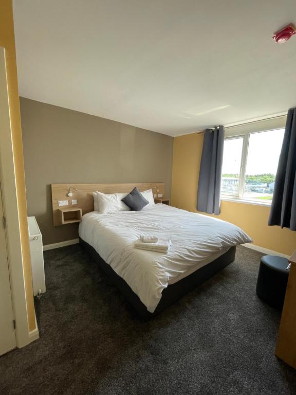 a bedroom with a large white bed with a window at Tinapa Suites in Manchester