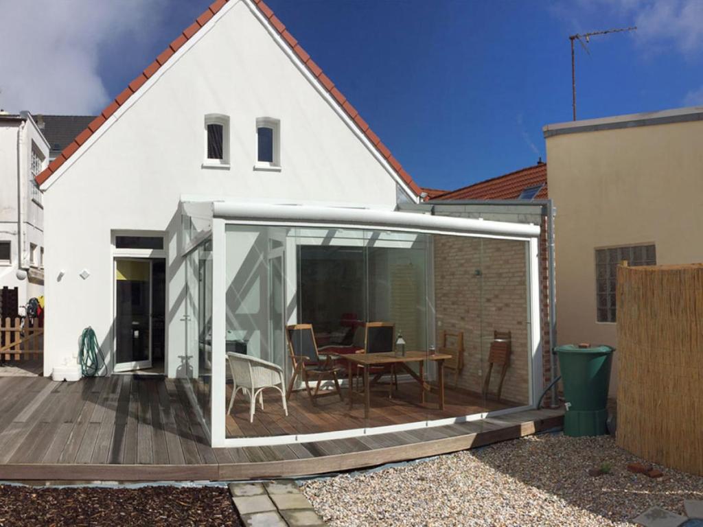 a white house with a deck with a table at Packhaus Norderney in Norderney