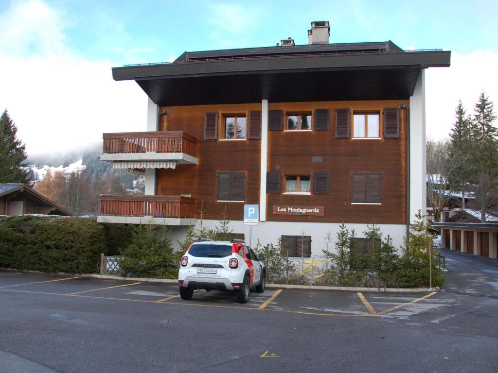 ein Auto, das auf einem Parkplatz vor einem Gebäude geparkt ist in der Unterkunft Apartment Montagnards 17 by Interhome in Villars-sur-Ollon