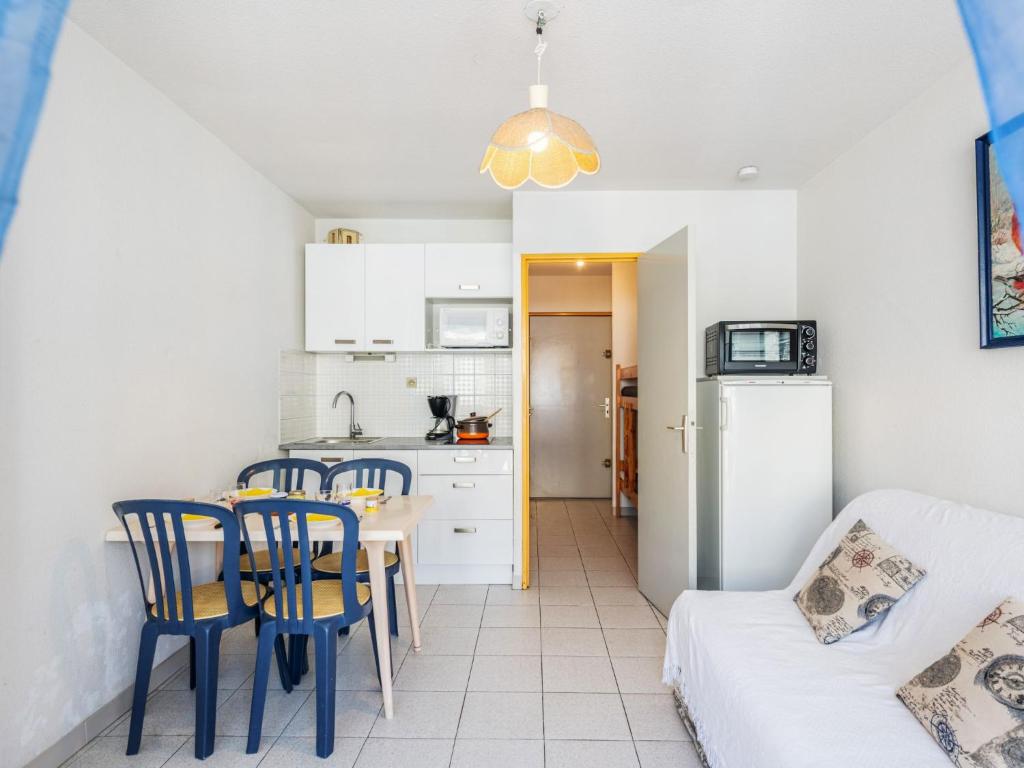 une cuisine et une salle à manger avec une table et des chaises dans l'établissement Studio Voiles d'Or-Gênois-4 by Interhome, au Grau-du-Roi