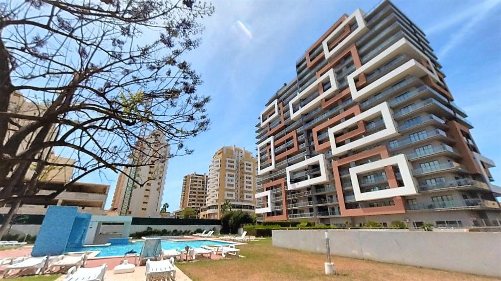 um grande edifício de apartamentos com uma piscina ao lado de um resort em Apartamentos Turisticos Rocha Tower 4 em Portimão