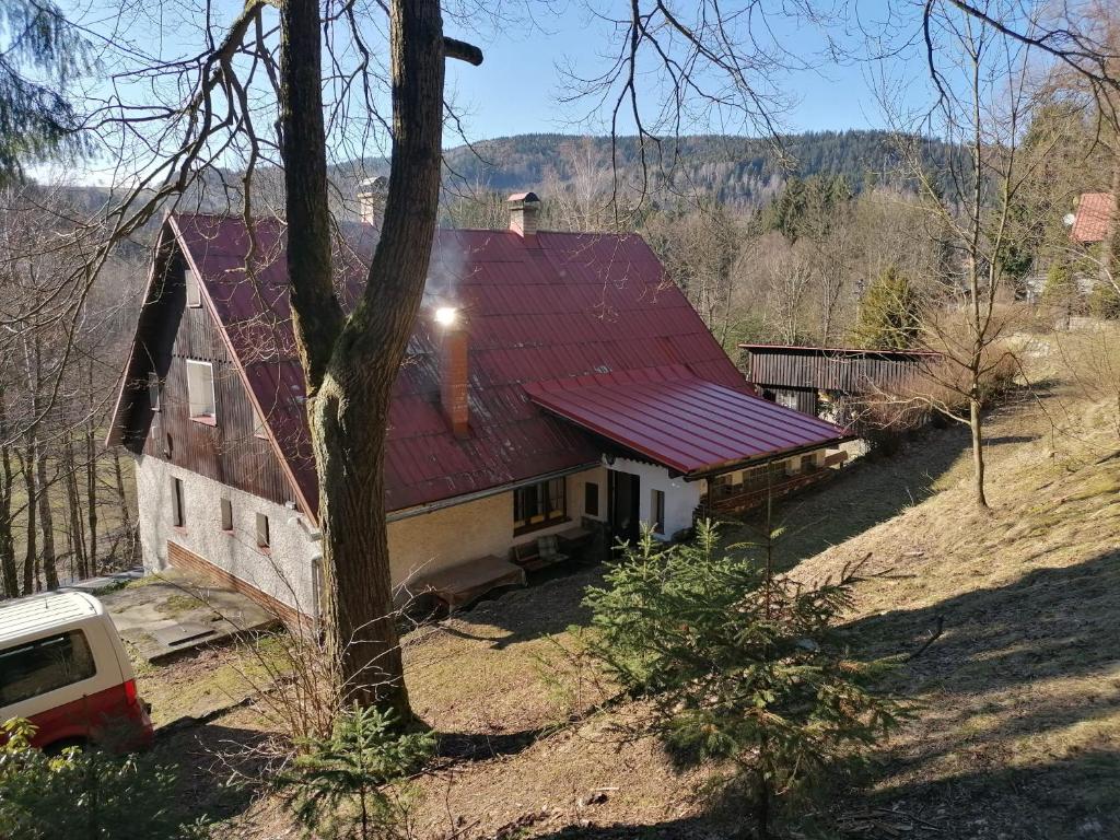 een huis met een rood dak op een heuvel bij Chalupa Tanvaldský Špičák in Tanvald