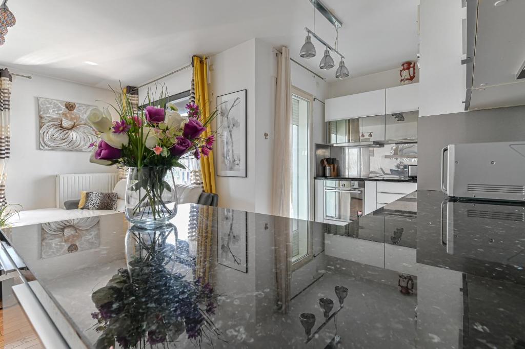un vase de fleurs sur un comptoir dans une cuisine dans l'établissement Appartement Glamour, à Paris