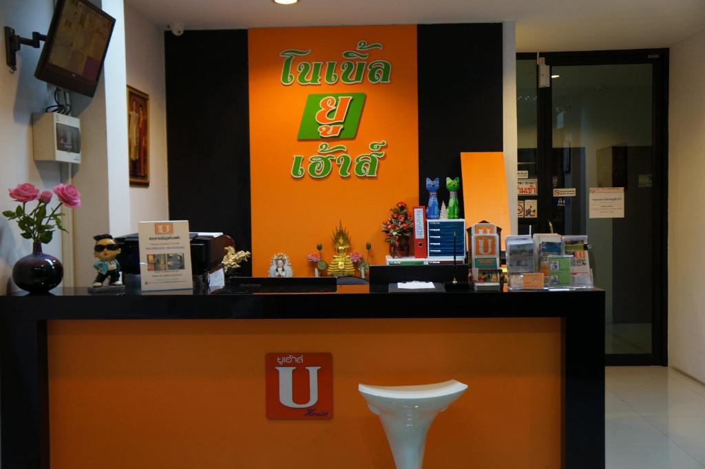 un comptoir dans un magasin avec un panneau orange dans l'établissement Noble U-house Chiangmai, à Chiang Mai