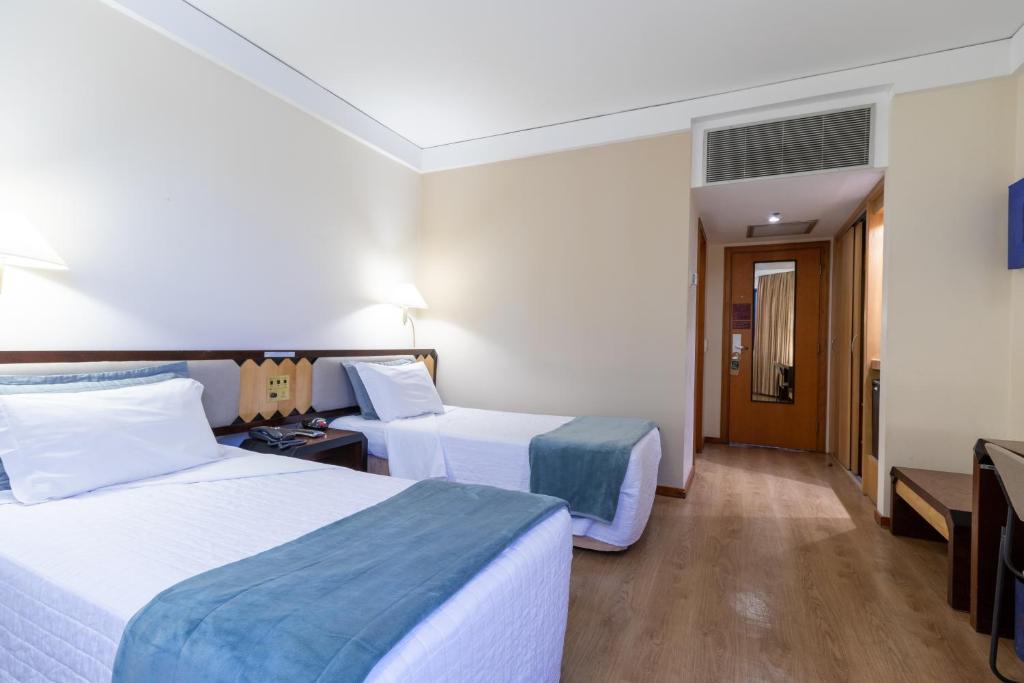 Un pat sau paturi într-o cameră la Golden Tower Pinheiros by Fênix Hotéis
