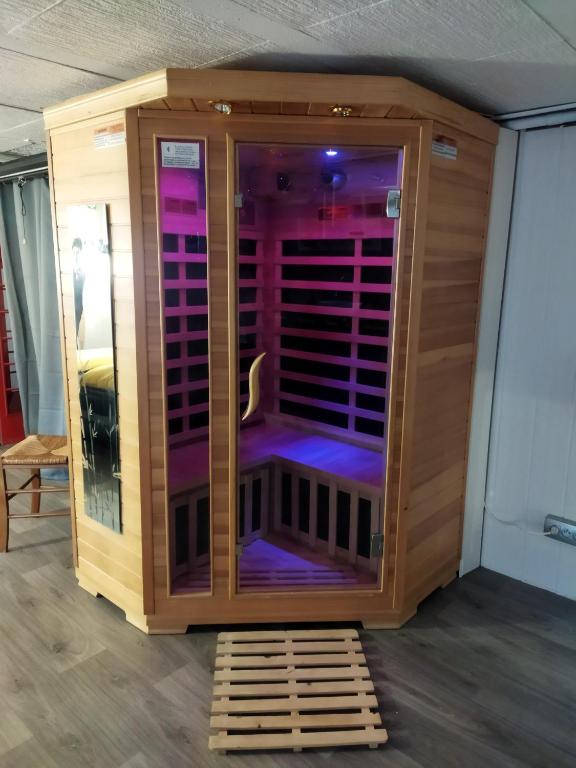 a wooden shower with purple lights in a room at La chambre secrète in Longueval