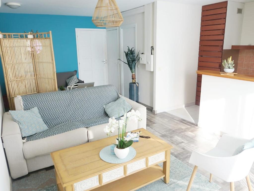 a living room with a couch and a coffee table at Manganao Loft Bord de mer in Belle-Allée