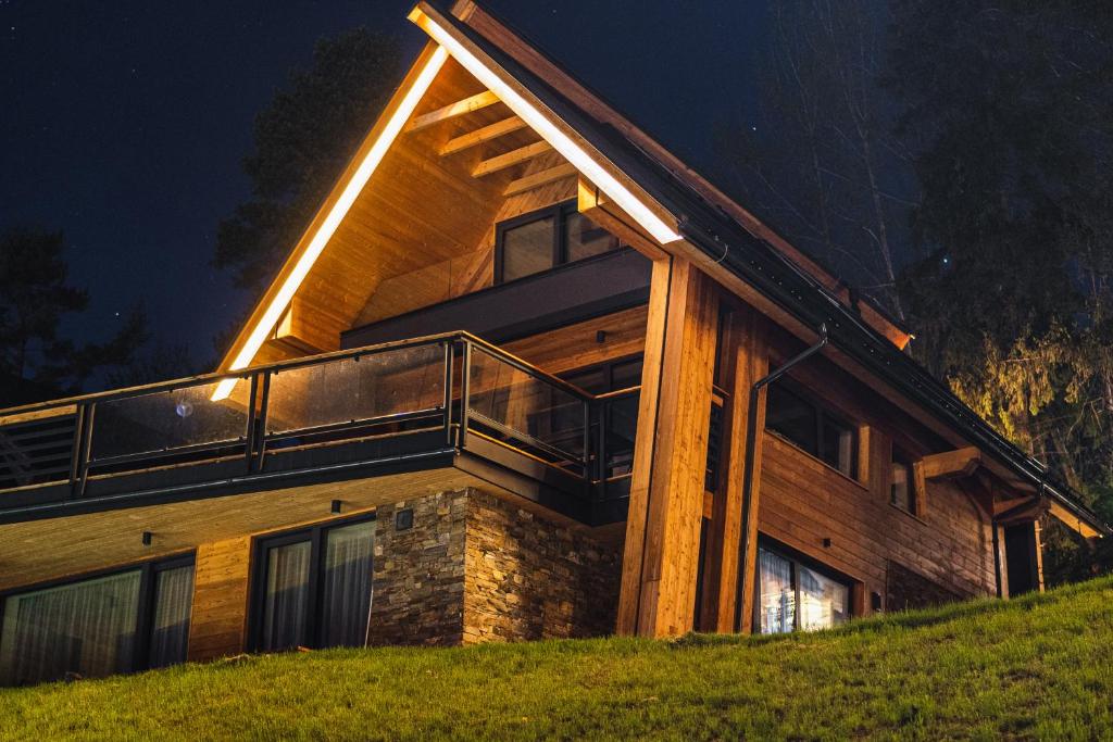 a house on a hill with a deck at night at Rezydencja Boutique SKI - 200m do Term Bania, Odkryj-Bialke in Białka Tatrzańska