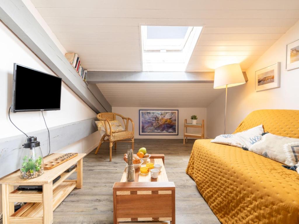 a living room with a yellow bed and a skylight at Apartment Berasteguia-5 by Interhome in Ciboure