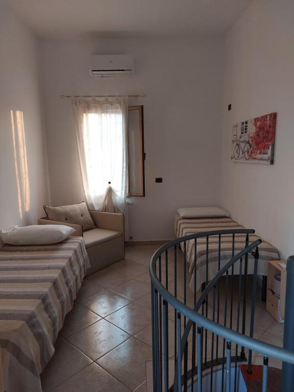 salon z 2 łóżkami i kanapą w obiekcie Baciata Dal Sole Home w mieście Monopoli