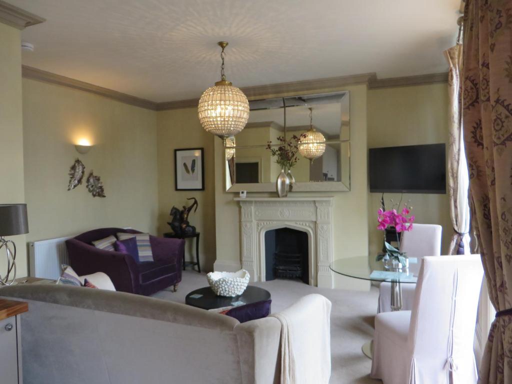 sala de estar con sofá y chimenea en Hewlett Apartments en Cheltenham