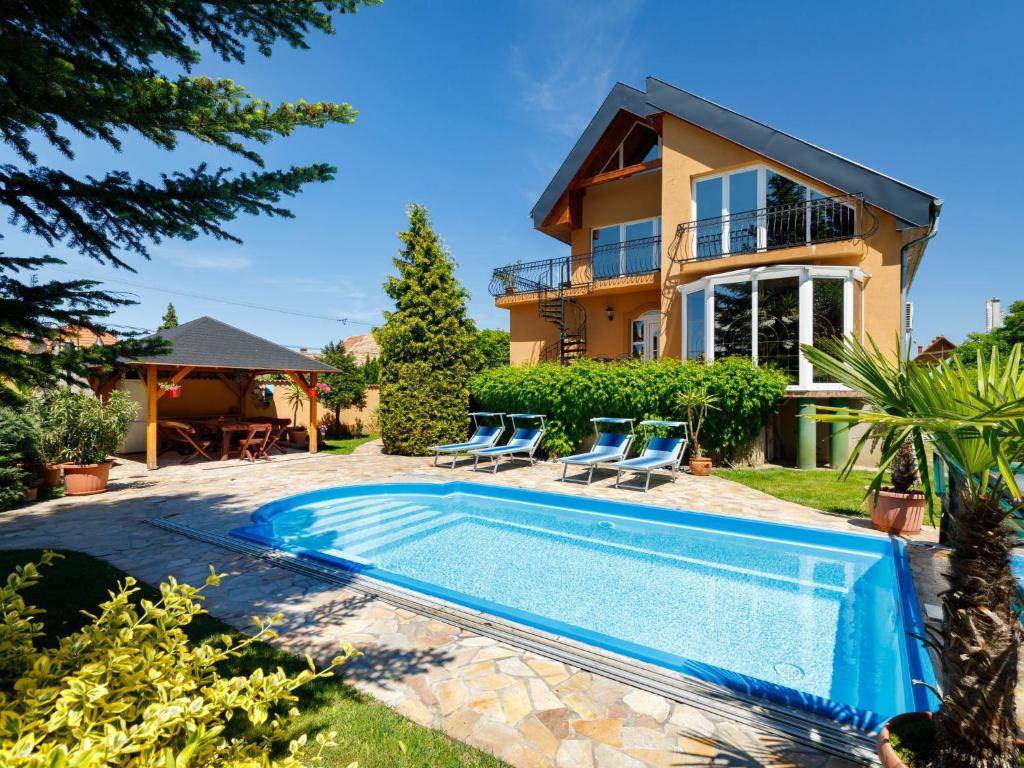 a villa with a swimming pool in front of a house at Holiday Home Szabo by Interhome in Balatonlelle