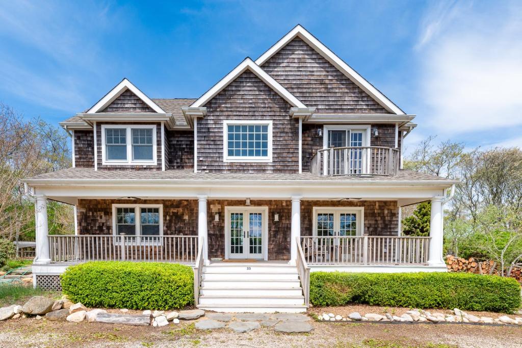 a house with a porch and bushes at Fort Pond Paradise in Montauk