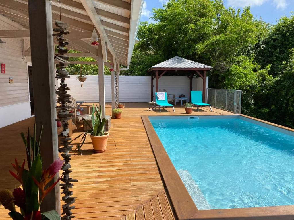 a patio with a swimming pool and a gazebo at VILLA DIAMANTILLES - MAISON D'HOTES in Le Diamant
