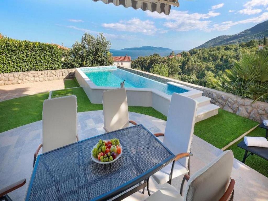 una mesa y sillas con un bol de fruta. en Villa Vita,free wifi,nearby sea, en Opatija