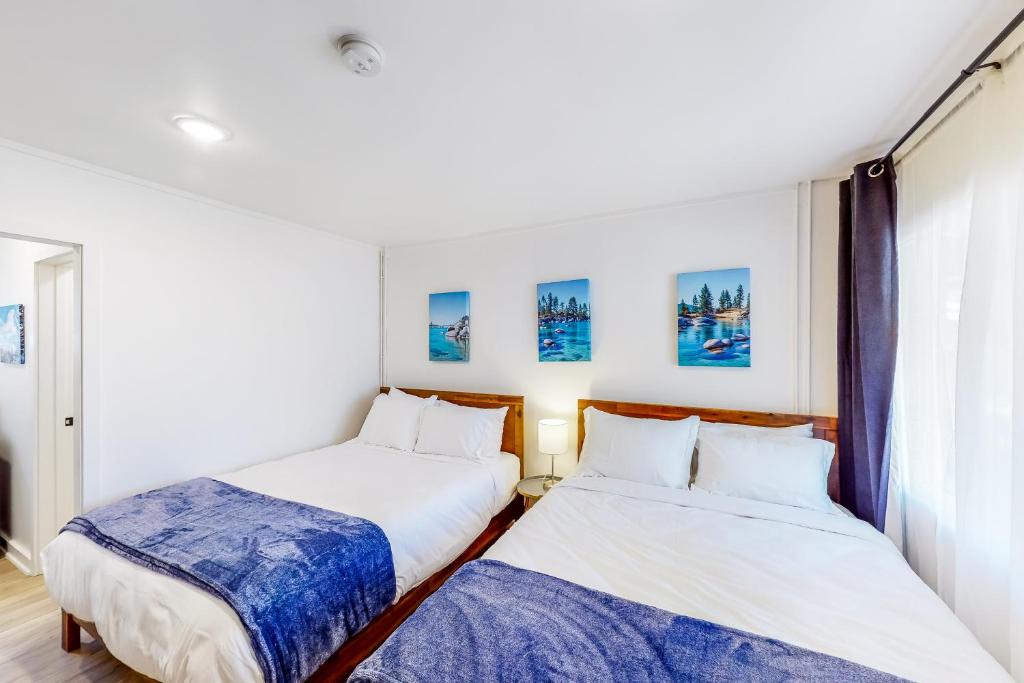 two twin beds in a room with a window at The Chalets at Kings Beach III in Kings Beach
