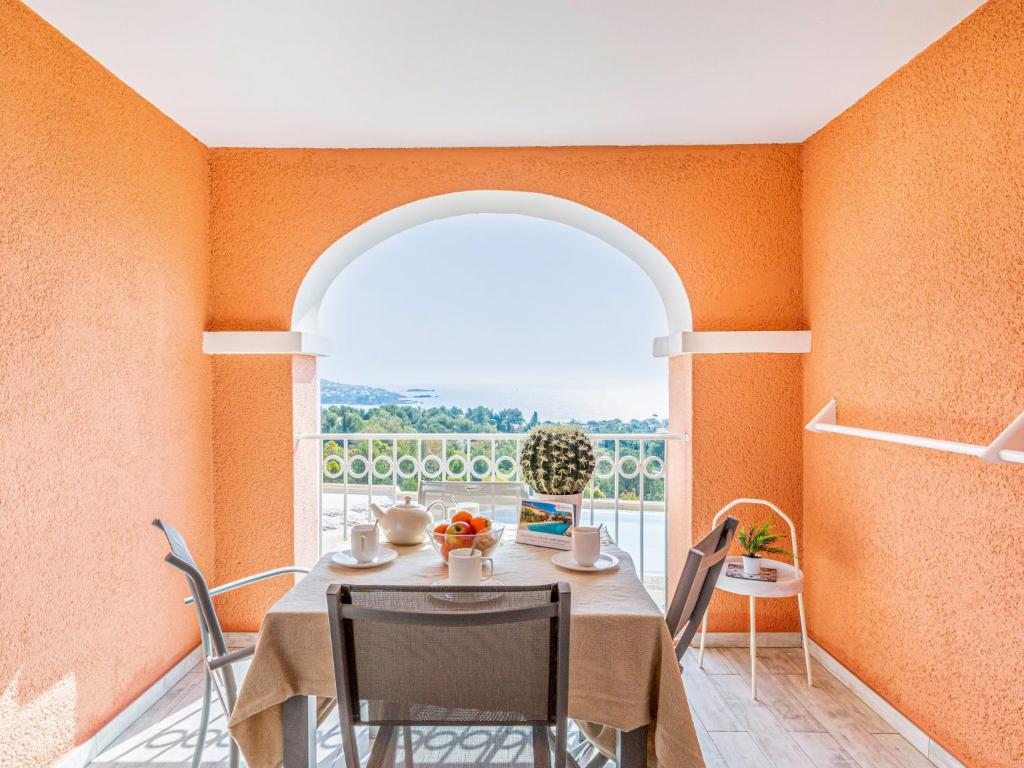 ein Esszimmer mit einem Tisch und einem großen Fenster in der Unterkunft Studio Village Cap Estérel - Le Hameau-1 by Interhome in Agay - Saint Raphael